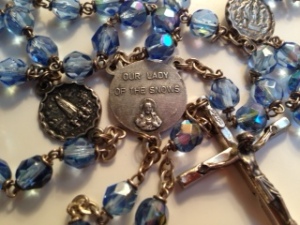 The title, Our Lady of the Snows, is engraved on the center medal of this rosary.